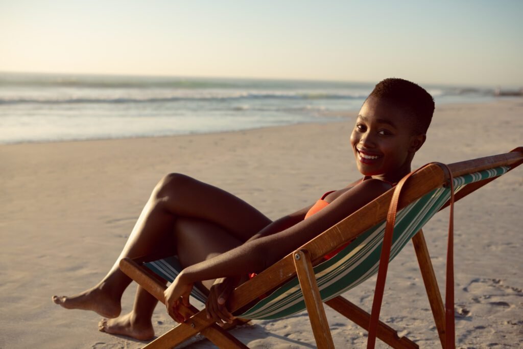 mulher feliz relaxante em uma cadeira de praia na praia